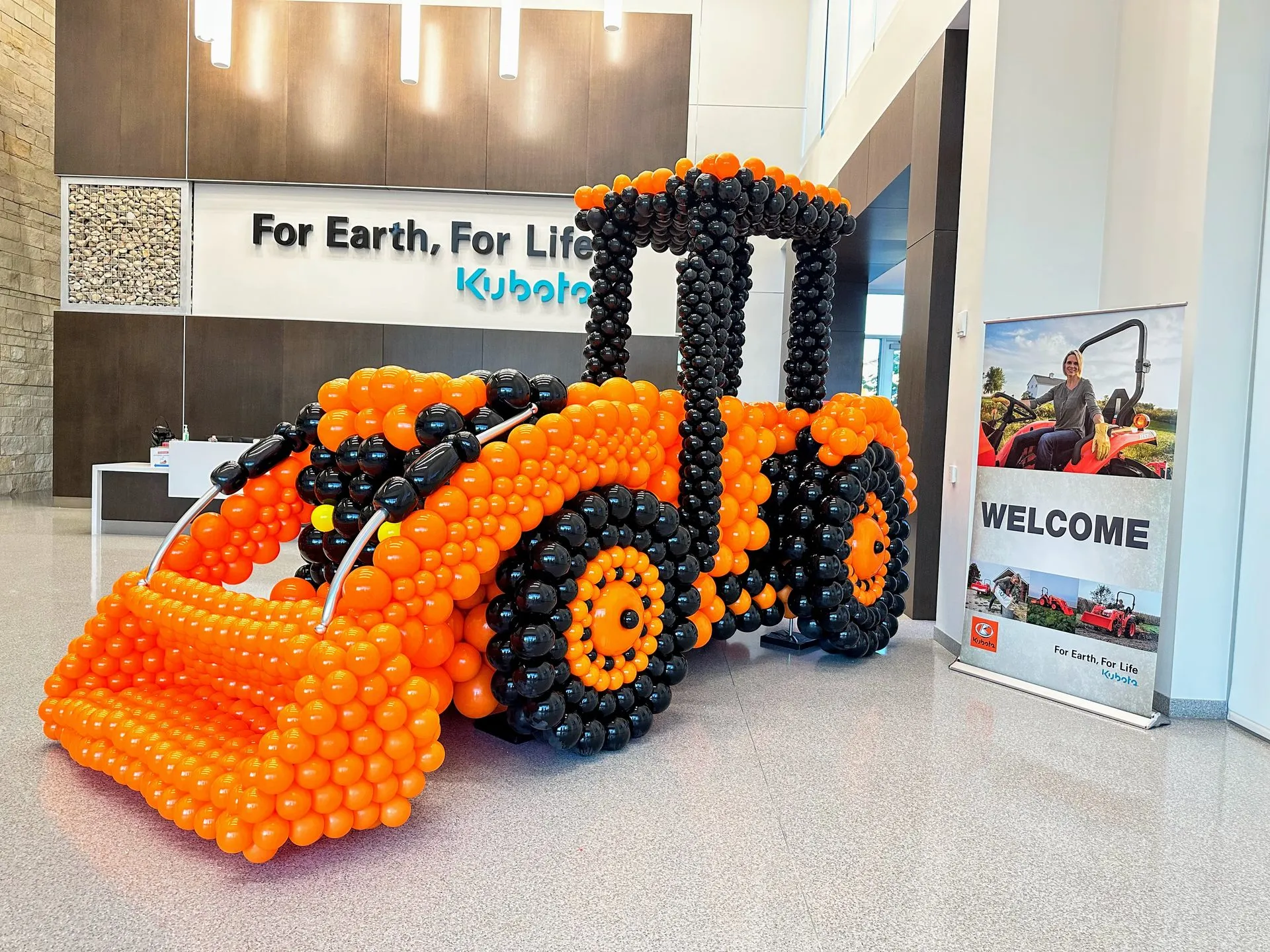 large balloon decor sculpture of an orange and black tractor