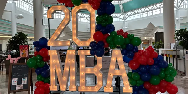 light up marquee spelling 20 MBA with balloon garland