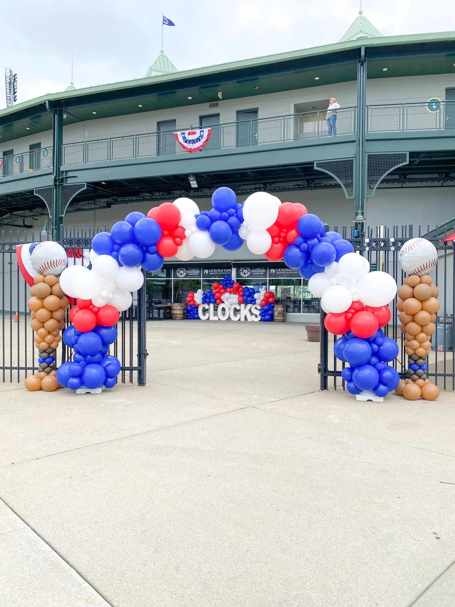 red, white, and blue balloon arch outside