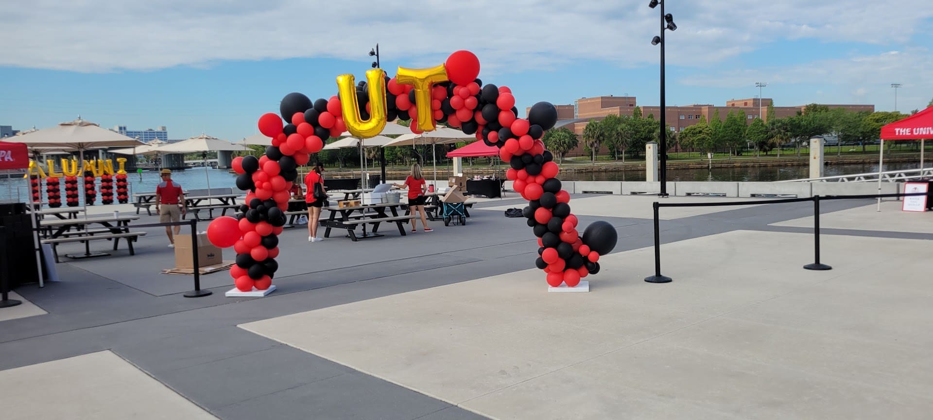 college alumni red and black balloon arch with balloon columns in background