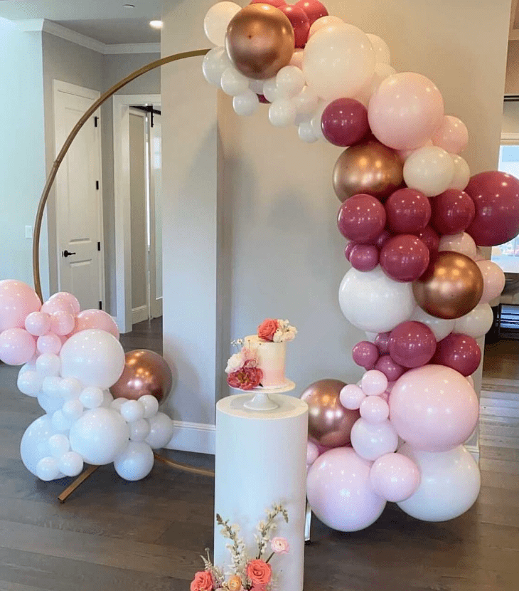 organic balloon decor backdrop with a cake