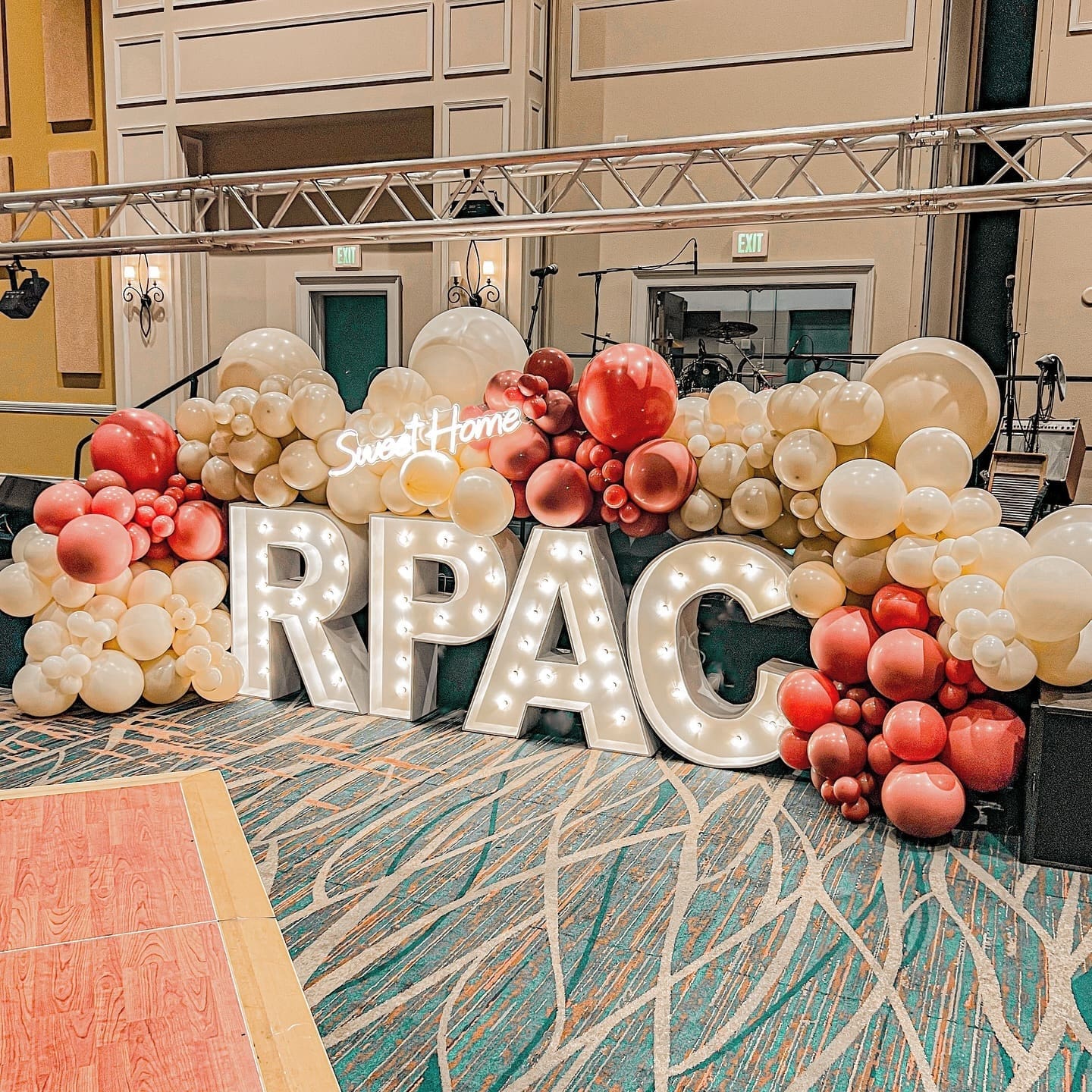 Light up marquee that says RPAC surrounded by a organic balloon garland