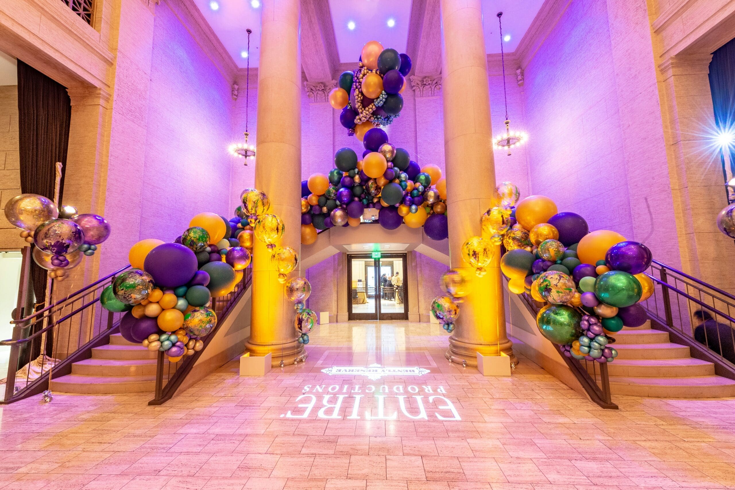 fancy custom balloon decor installation on step railing inside a luxurious building