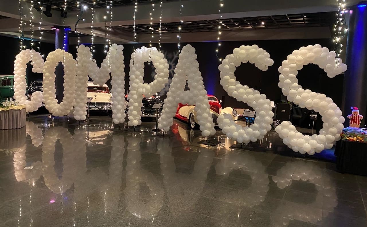 large white letters created with white balloons that spell out COMPASS