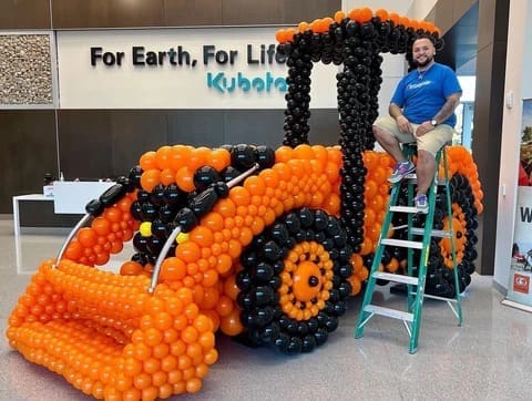 large orange and black balloon sculpture of tractor