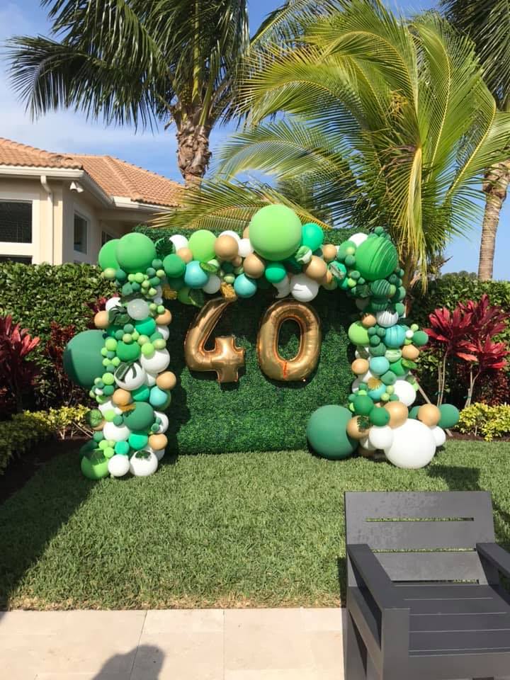 green outdoor balloon backdrop for 40th birthday