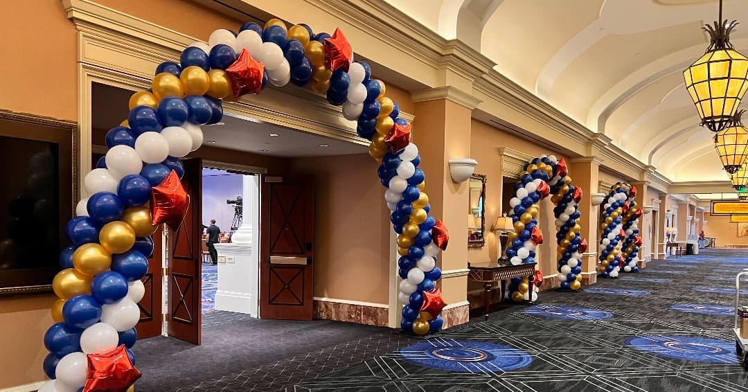 red, white, and blue balloon arches inside a nice building