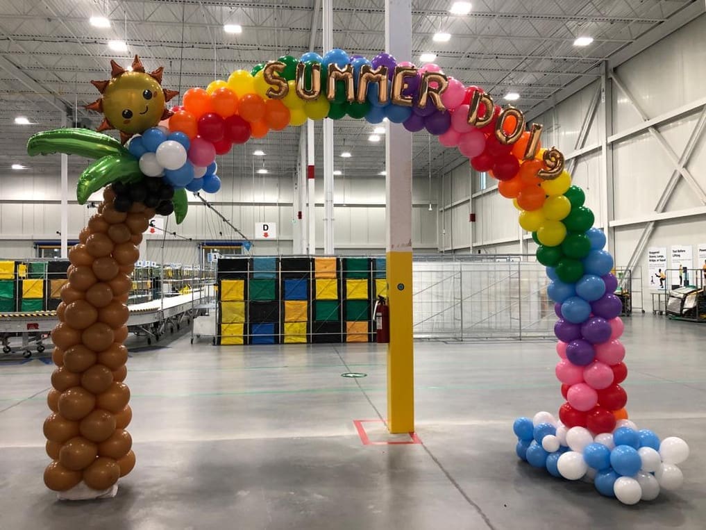 summer themed balloon arch in a factory setting